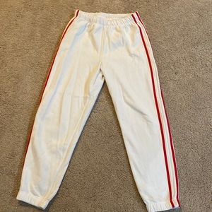 White sweats with red stripe lining go down from the sides